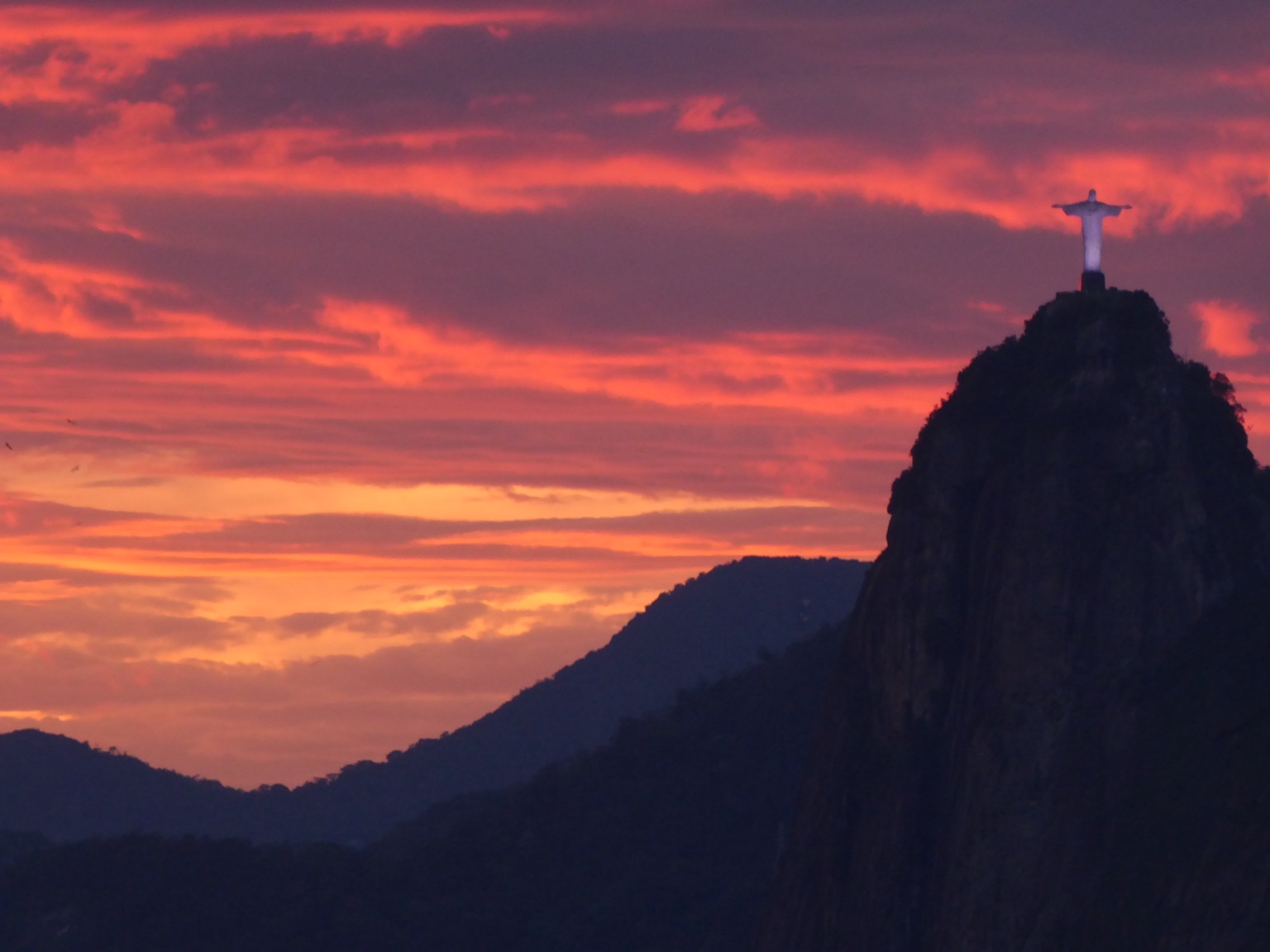 Christ the Redeemer silhouetted against a vivid Rio sunset